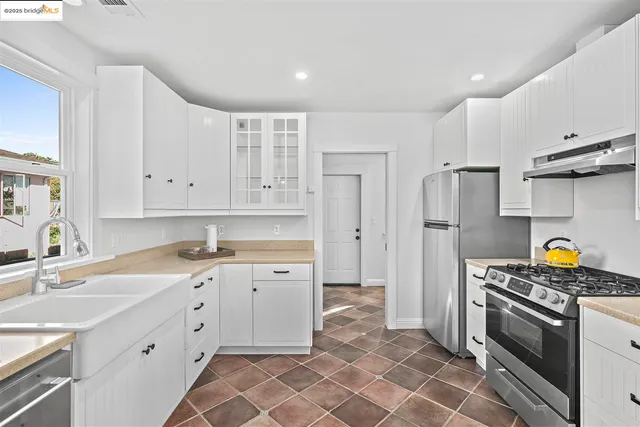 a kitchen with stainless steel appliances a stove a sink and a refrigerator