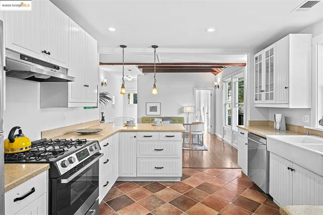 a kitchen with stainless steel appliances a stove a sink and a refrigerator