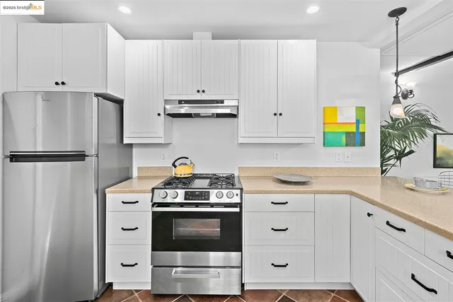 a kitchen with stainless steel appliances white cabinets and a stove