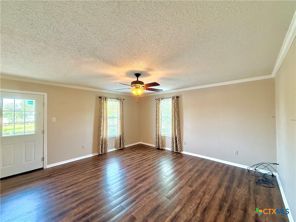 109 River Road Tivoli, TX 77990 - Photo 11 of 39 an empty room with wooden floor chandelier fan and windows