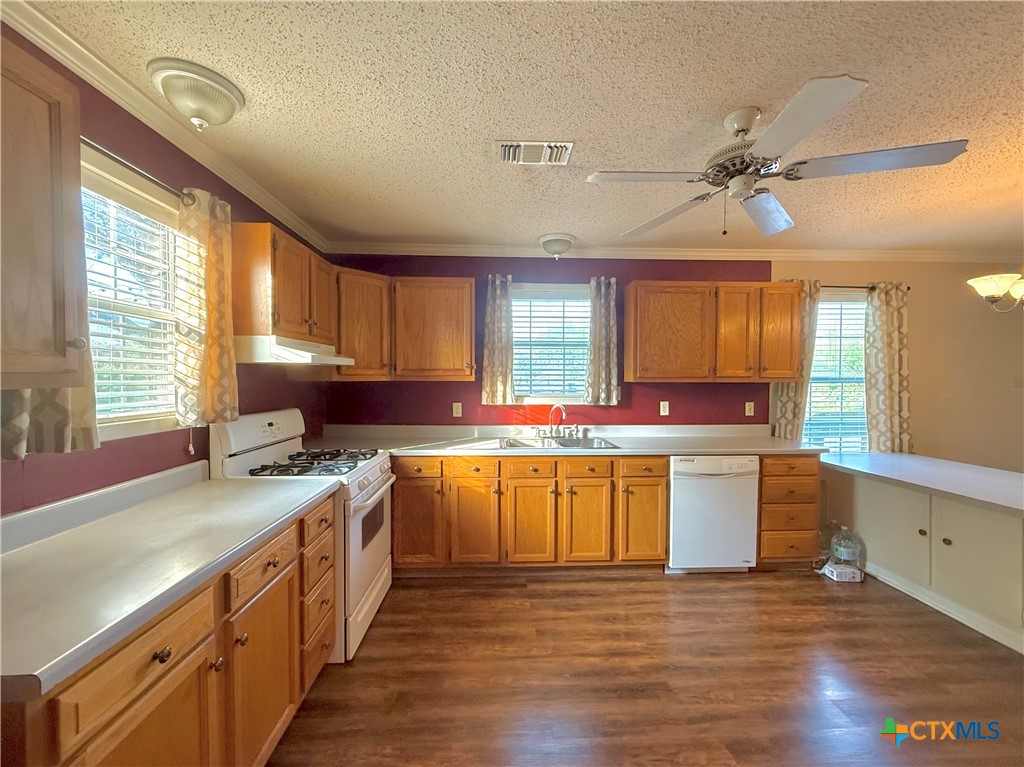 109 River Road Tivoli, TX 77990 - Photo 23 of 39 a kitchen with stainless steel appliances a sink cabinets wooden floor and a window