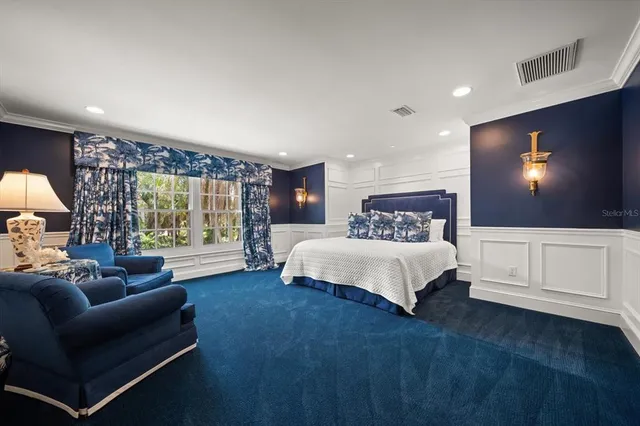 a front view of a house with a garden and lake view