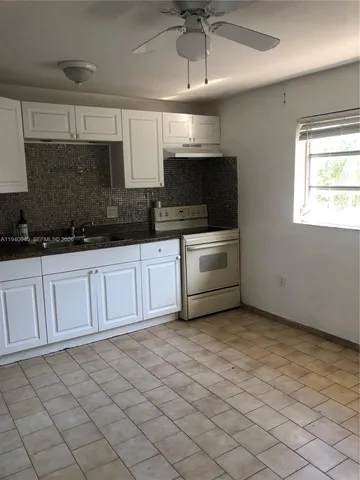 a kitchen with stainless steel appliances granite countertop a sink a stove top oven a counter space and cabinets