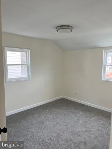 a white toilet sitting next to a white wall
