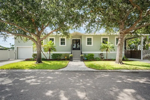 a front view of a house with a yard and trees
