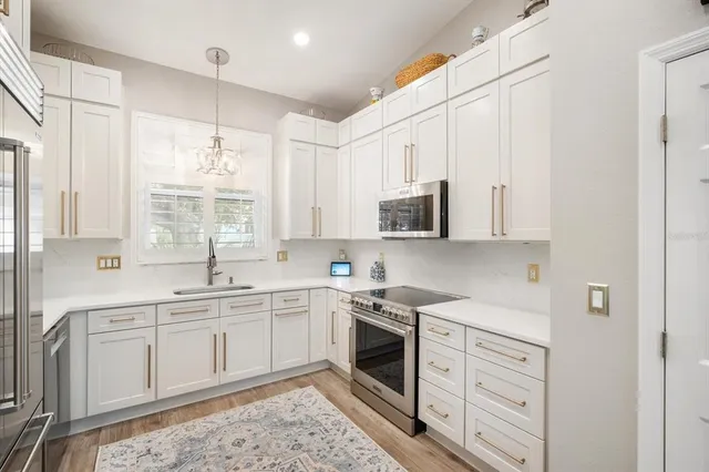 a kitchen with white cabinets stainless steel appliances and sink