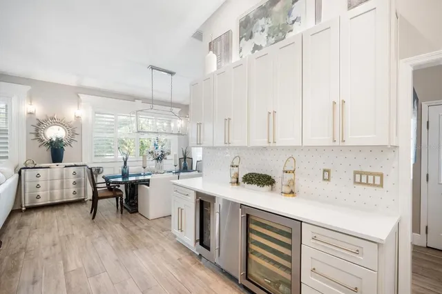 a kitchen with a sink dishwasher stove and white cabinets with wooden floor