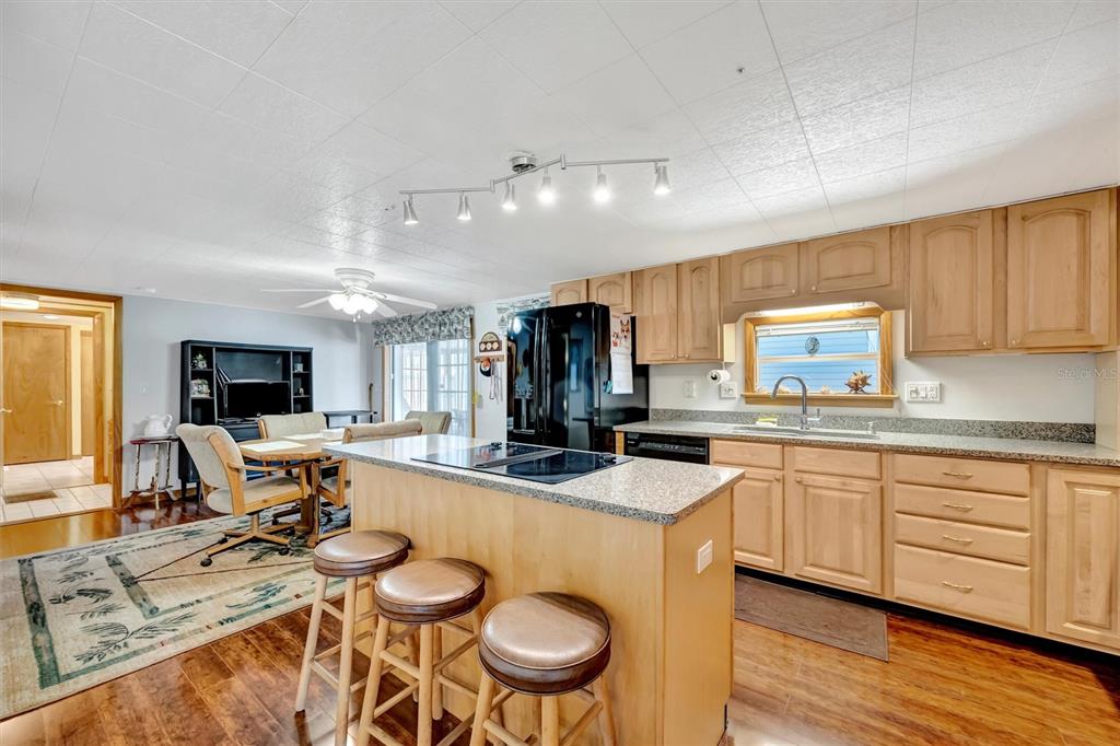 132 West St Lucia Loop Apollo Beach, FL 33572 - Photo 11 of 57 a kitchen with stainless steel appliances granite countertop a stove top oven a sink dishwasher and white cabinets with wooden floor