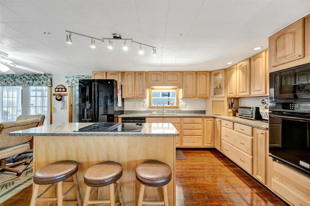 132 West St Lucia Loop Apollo Beach, FL 33572 - Photo 12 of 57 a kitchen with stainless steel appliances granite countertop a stove a sink a microwave a refrigerator and chairs