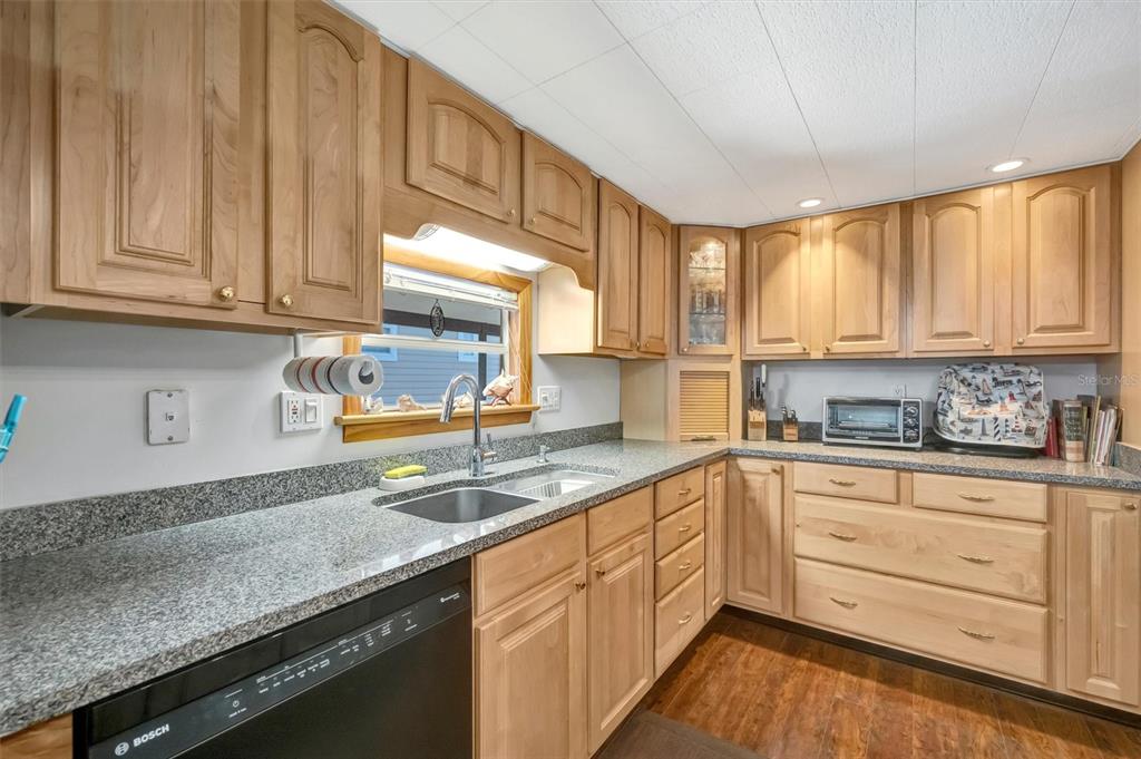 132 West St Lucia Loop Apollo Beach, FL 33572 - Photo 6 of 57 a kitchen with granite countertop a sink cabinets stainless steel appliances and a window