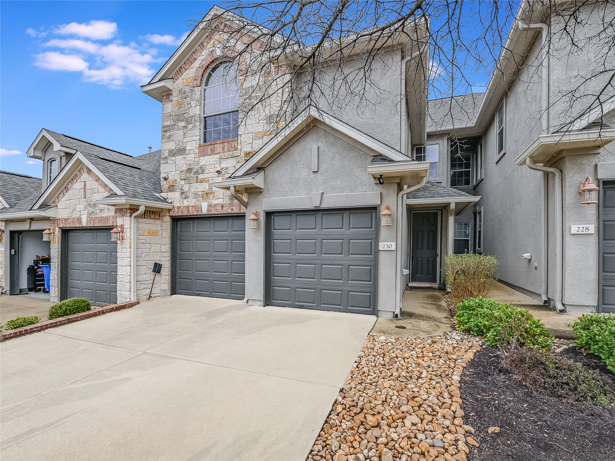230 Sunrise Ridge Loop Austin, TX 78738 - Photo 1 of 27 A striking exterior featuring stone and stucco finishes with an inviting entrance and integrated garage access.
