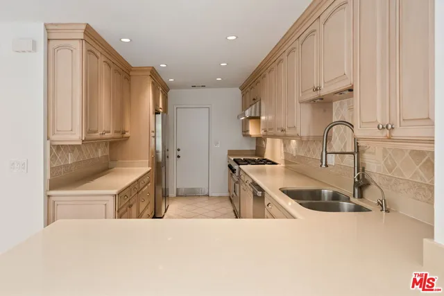a kitchen with stainless steel appliances a refrigerator and a stove