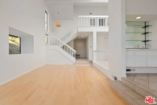 a view of a hallway with white walls and entryway