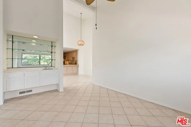 an empty room with kitchen and windows