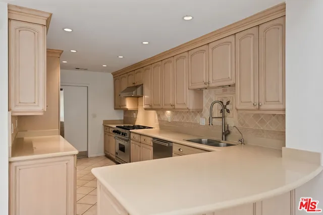 a kitchen with granite countertop a sink a stove and a refrigerator