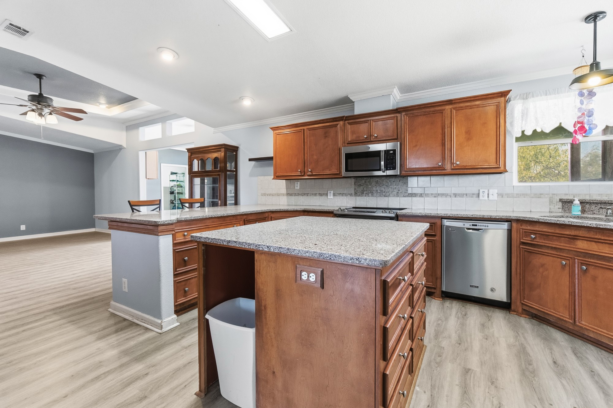 1951 Dowdy Road Seguin, TX 78155 - Photo 6 of 40 Rich wood cabinetry and stone countertops anchor this central kitchen space under recessed lighting.