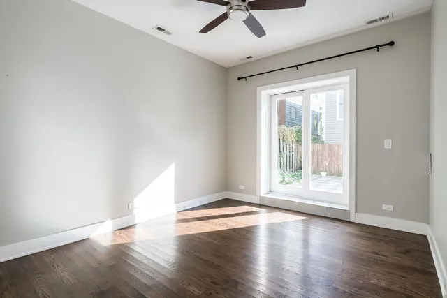 an empty room with wooden floor and white walls