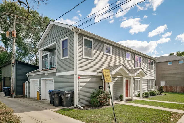 a view of a building with a bench and potted plants