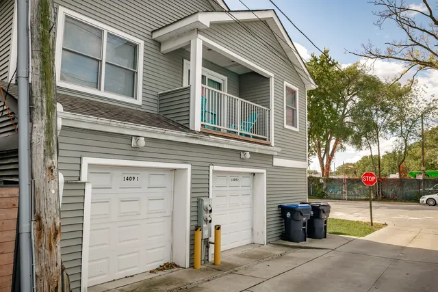a view of a house with a garage and large tree