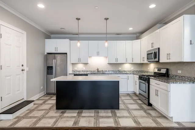 a kitchen with stainless steel appliances granite countertop a stove a sink a refrigerator and a microwave