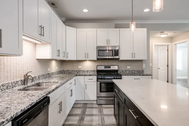 a kitchen with stainless steel appliances granite countertop a sink stove and cabinets
