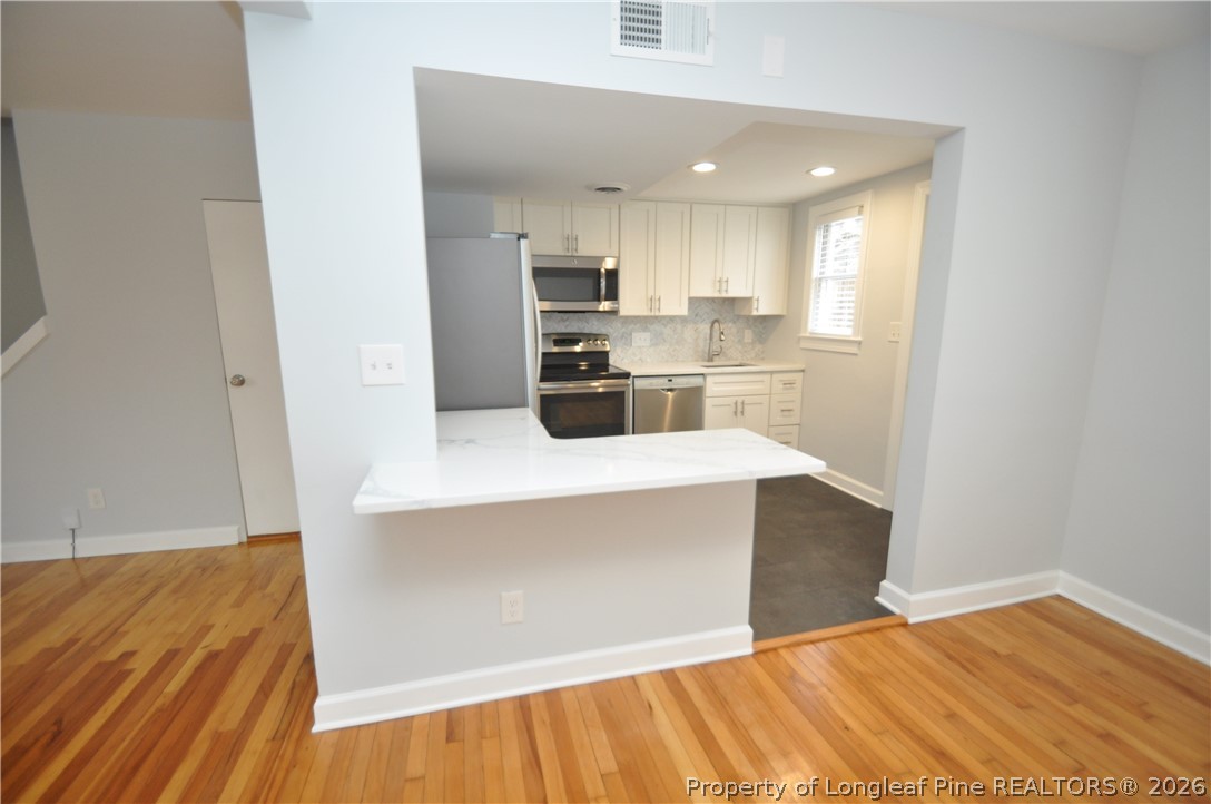 1008 Nichols Drive Raleigh, NC 27605 - Photo 14 of 33 a kitchen with stainless steel appliances a refrigerator and a counter top space