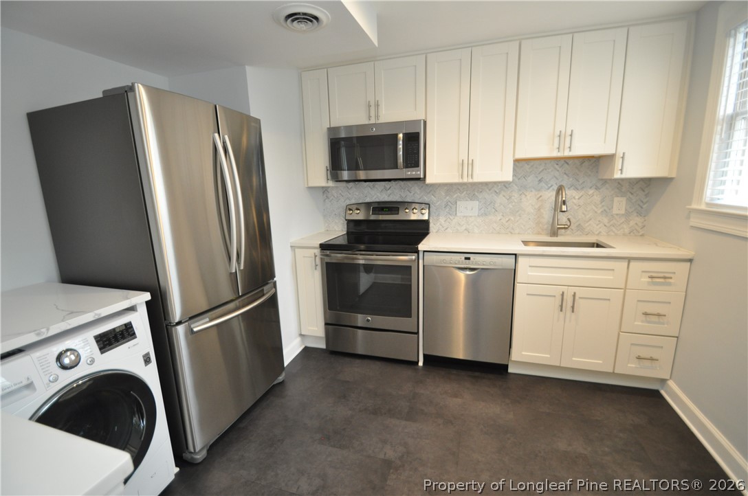 1008 Nichols Drive Raleigh, NC 27605 - Photo 15 of 33 a view of a kitchen with refrigerator stove and wooden cabinets