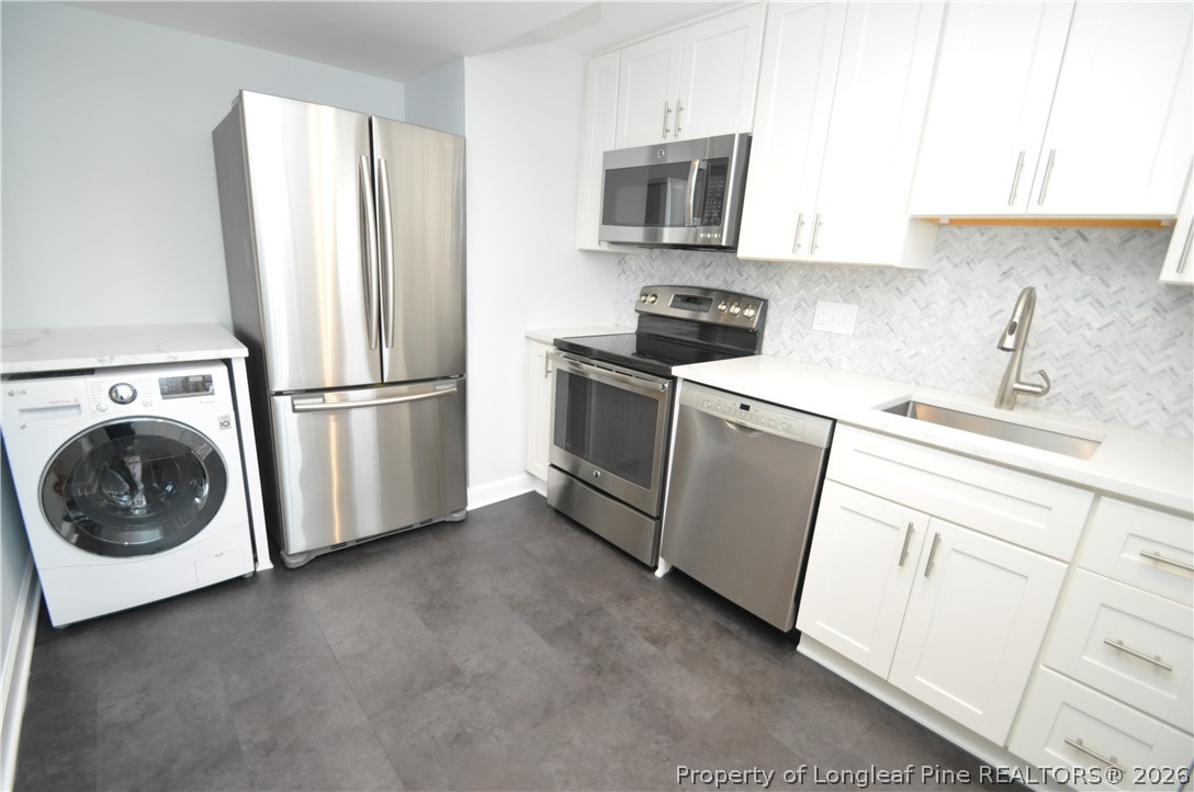 1008 Nichols Drive Raleigh, NC 27605 - Photo 16 of 33 a kitchen with white cabinets and stainless steel appliances