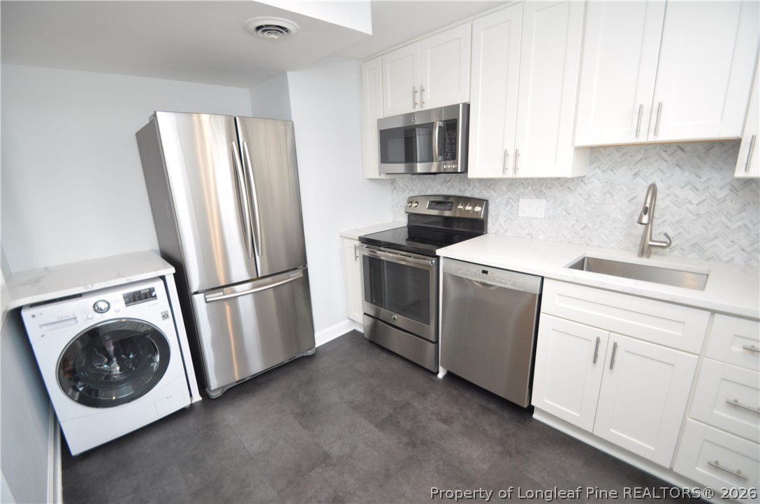 1008 Nichols Drive Raleigh, NC 27605 - Photo 20 of 33 a kitchen with white cabinets and stainless steel appliances