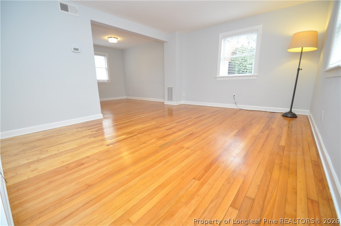 1008 Nichols Drive Raleigh, NC 27605 - Photo 6 of 33 a view of an empty room with wooden floor and a window