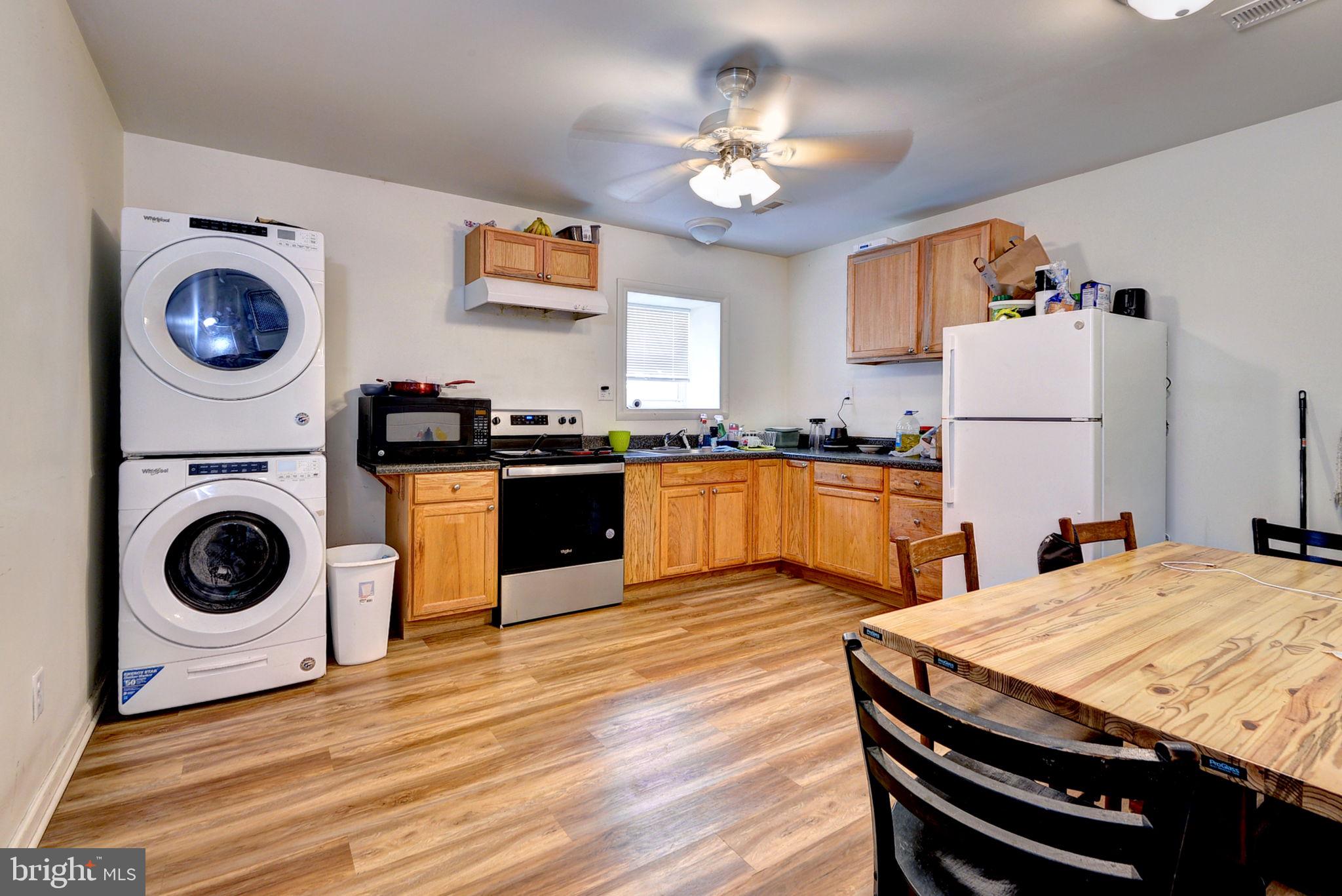 1025 Goodluck Road Lancaster, VA 22503 - Photo 131 of 132 a kitchen with kitchen island a stove a sink dishwasher and white cabinets with wooden floor