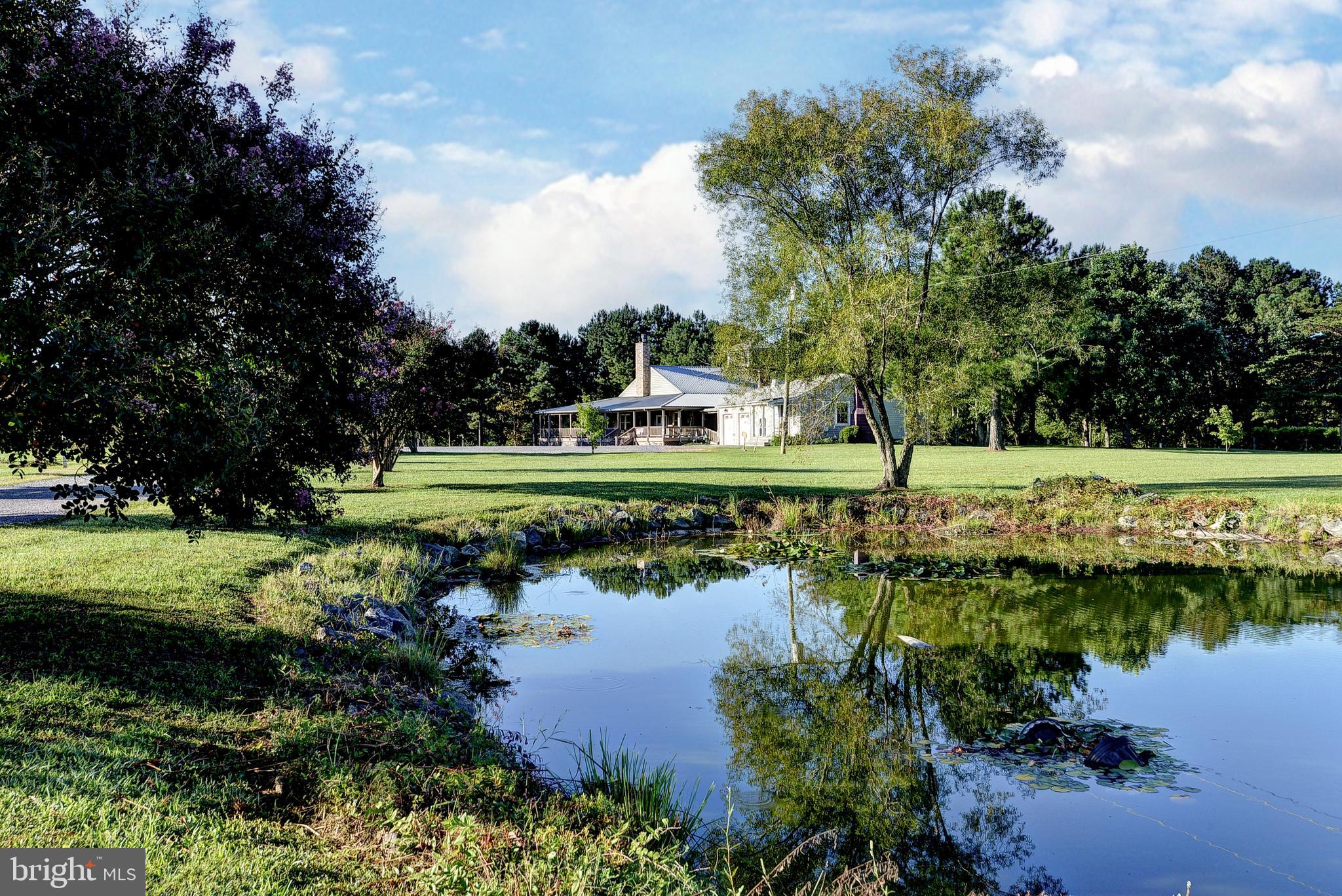 1025 Goodluck Road Lancaster, VA 22503 - Photo 5 of 132 a view of a lake with a yard and outdoor seating