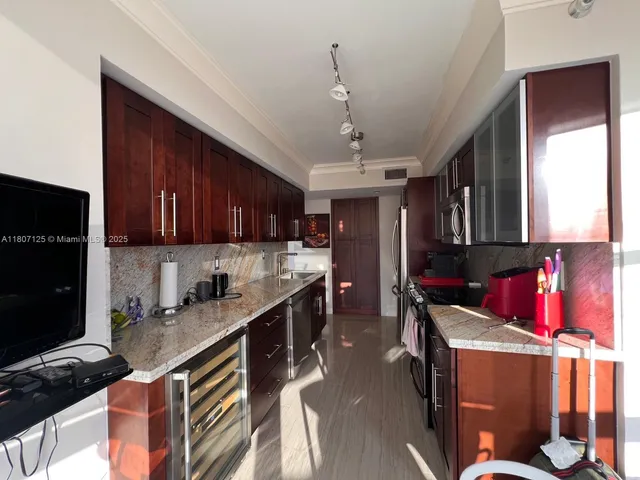 a kitchen that has a lot of cabinets in it and wooden floors