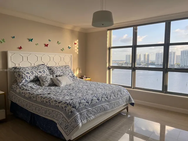 a large bed sitting in a bedroom next to a window