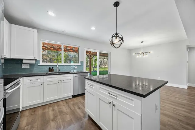 a kitchen with granite countertop a sink cabinets and window
