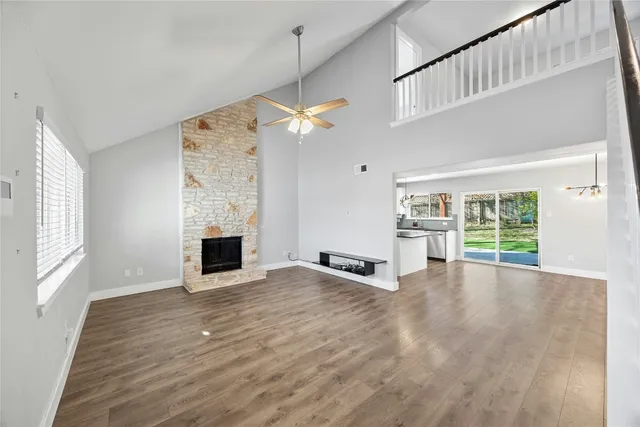a view of an empty room with a fireplace and a window