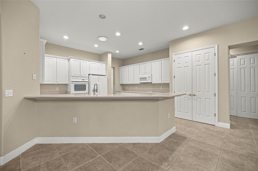 9512 Southeast 124th Loop Summerfield, FL 34491 - Photo 16 of 76 a large white kitchen with kitchen island a sink stainless steel appliances and cabinets