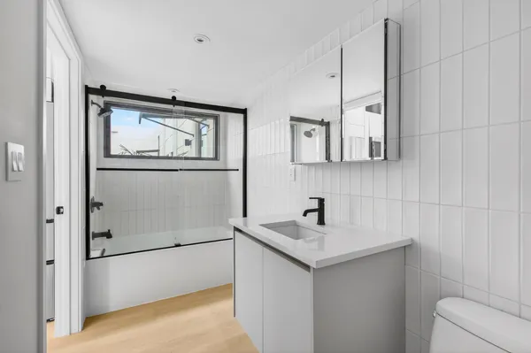 a view of a livingroom with furniture and staircase with a floor to ceiling window