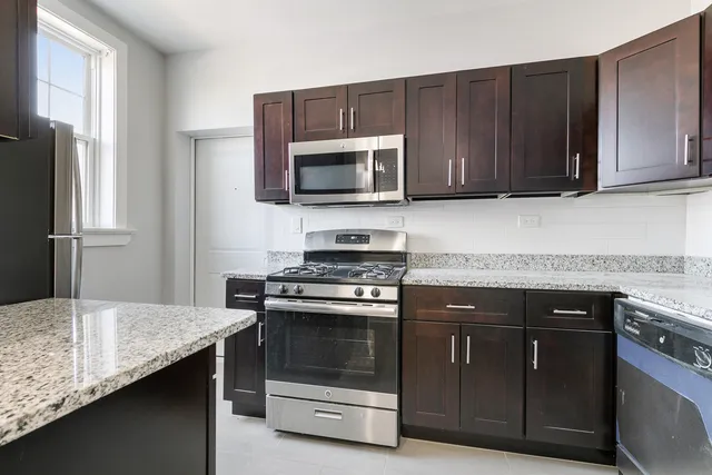 a kitchen with granite countertop wooden cabinets and stainless steel appliances