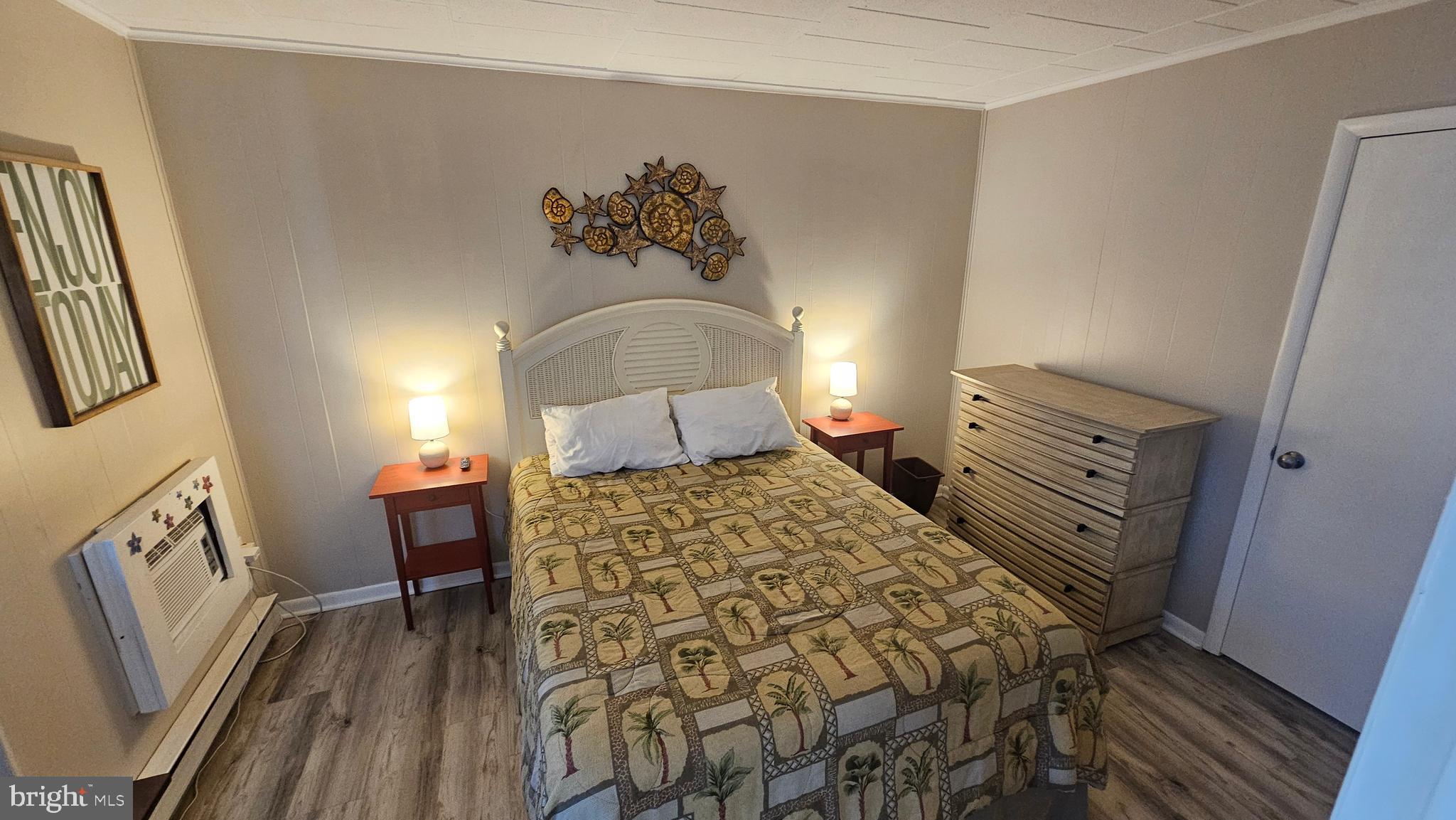 745 Mooring Road, Unit 111 Ocean City, MD 21842 - Photo 12 of 24 a bedroom with a bed and wooden floor