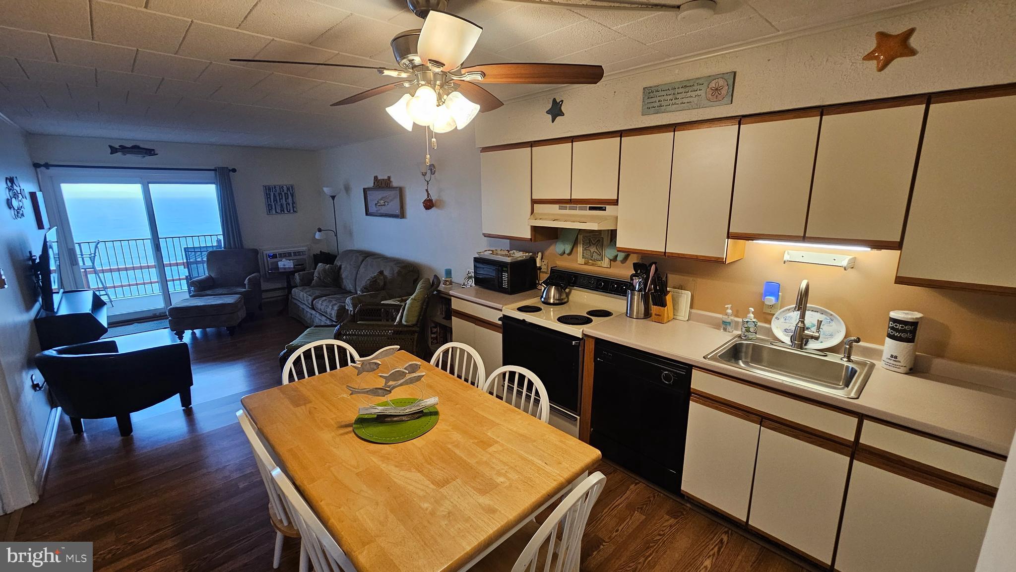 745 Mooring Road, Unit 111 Ocean City, MD 21842 - Photo 5 of 24 a kitchen with a refrigerator a stove a sink dishwasher and wooden cabinets with wooden floor