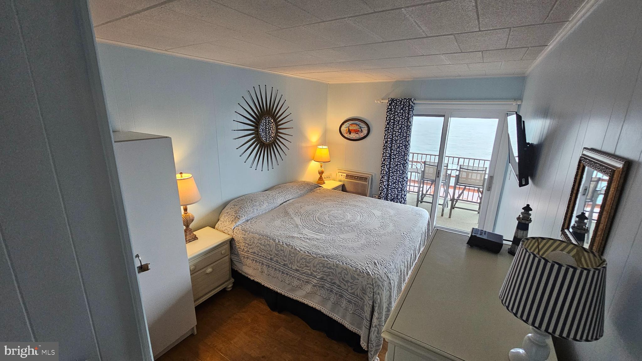 745 Mooring Road, Unit 111 Ocean City, MD 21842 - Photo 9 of 24 a bedroom with a bed a mirror and a large window