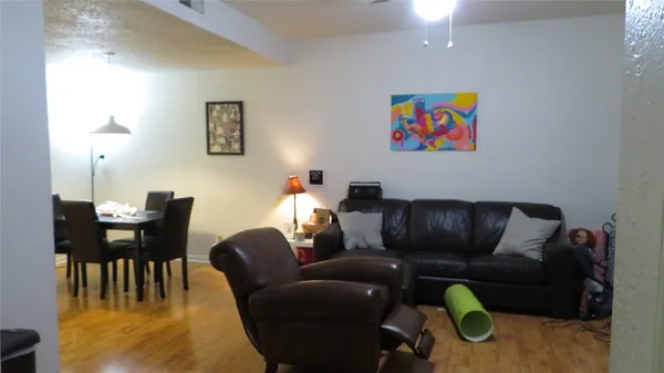 a living room with furniture and a dining table with rug
