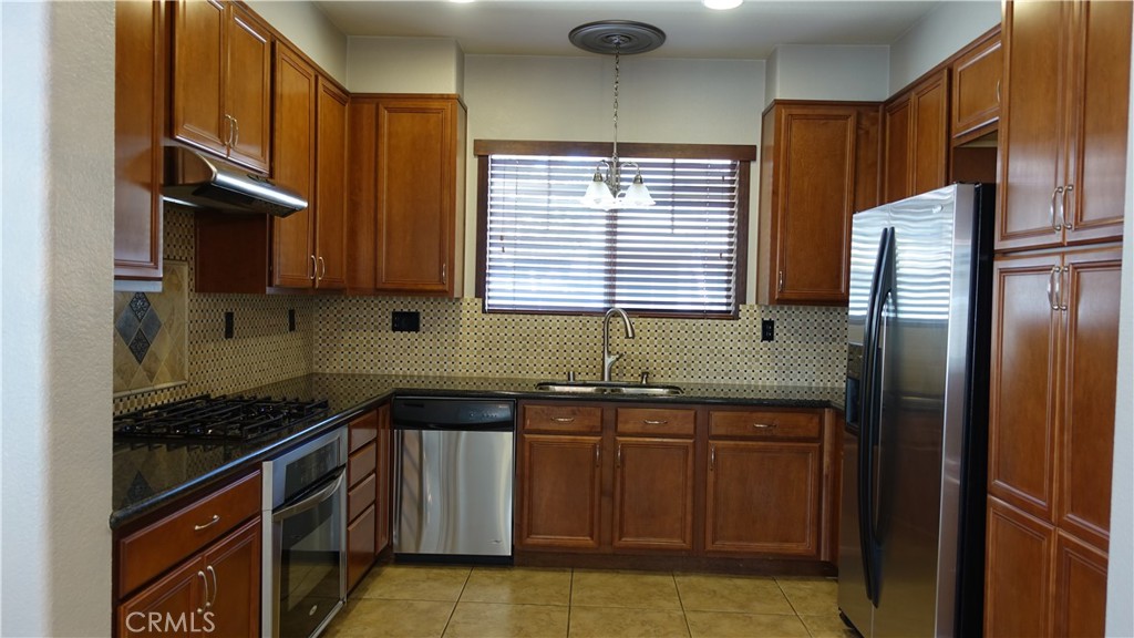 33953 Lily Road Yucaipa, CA 92399 - Photo 3 of 38 a kitchen with stainless steel appliances granite countertop a sink stove and refrigerator