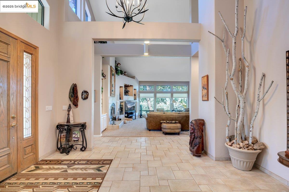 13700 Clements Road Groveland, CA 95321 - Photo 25 of 93 Entrance foyer featuring a towering ceiling, a fireplace, and a chandelier