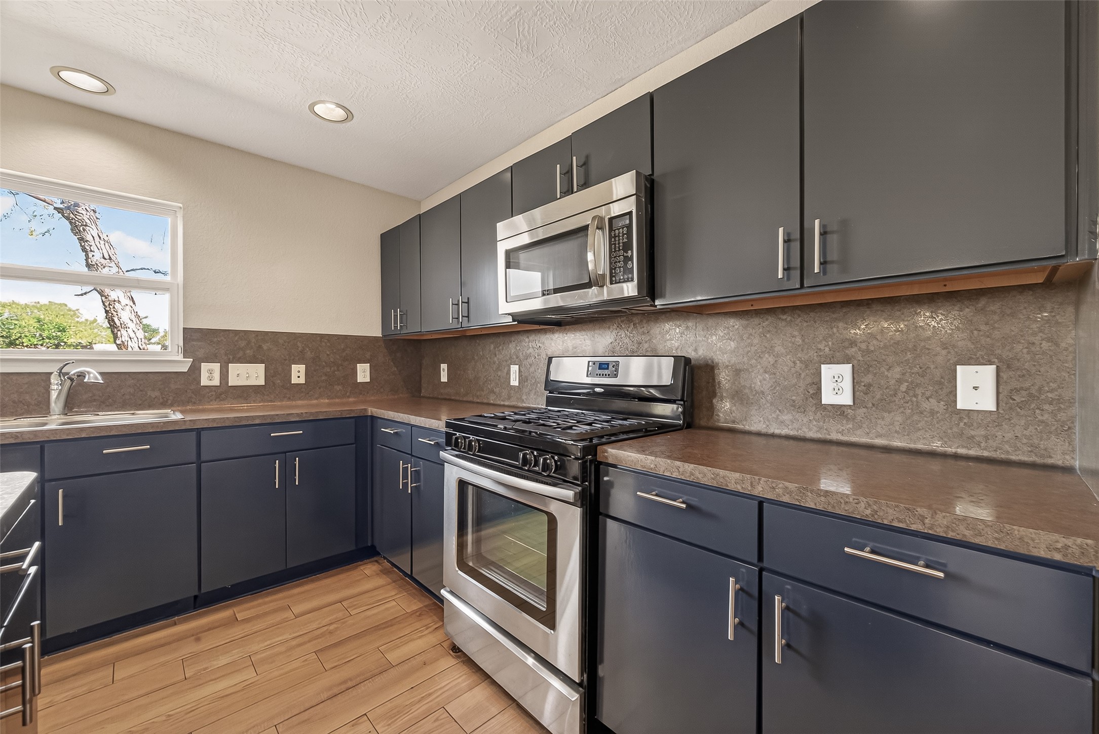 4515 Apache Point Drive Humble, TX 77396 - Photo 16 of 36 a kitchen with stainless steel appliances granite countertop a stove a sink and a microwave
