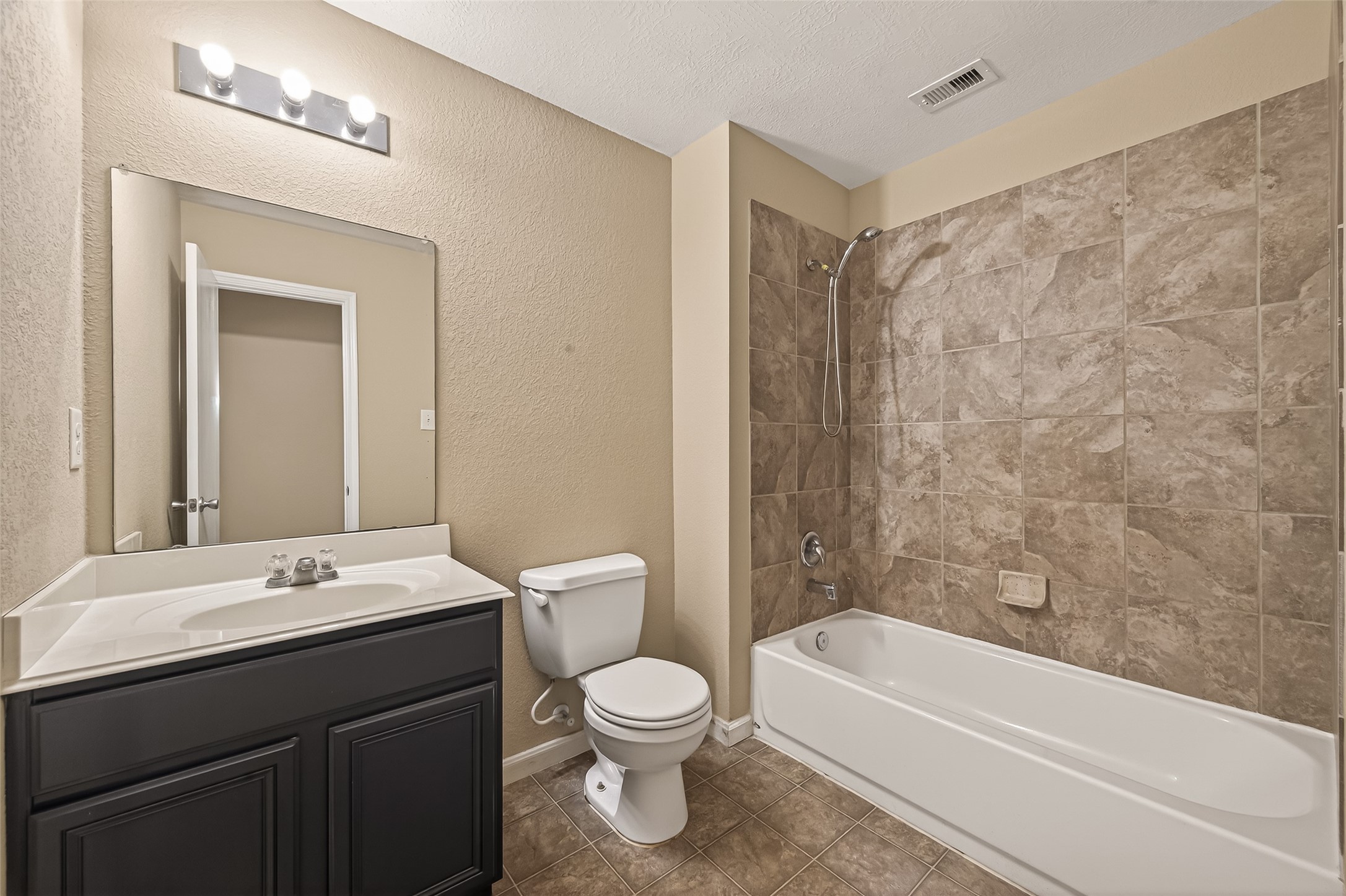4515 Apache Point Drive Humble, TX 77396 - Photo 21 of 36 a bathroom with a sink a toilet a mirror and a bathtub