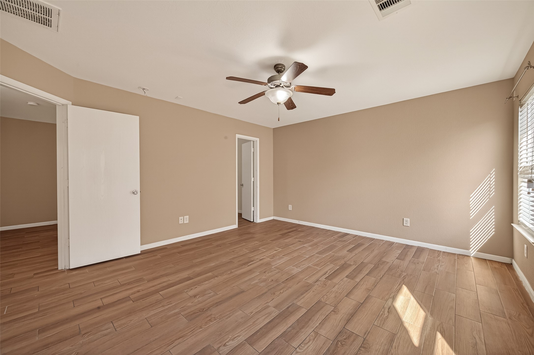 4515 Apache Point Drive Humble, TX 77396 - Photo 27 of 36 a view of an empty room with wooden floor and a ceiling fan
