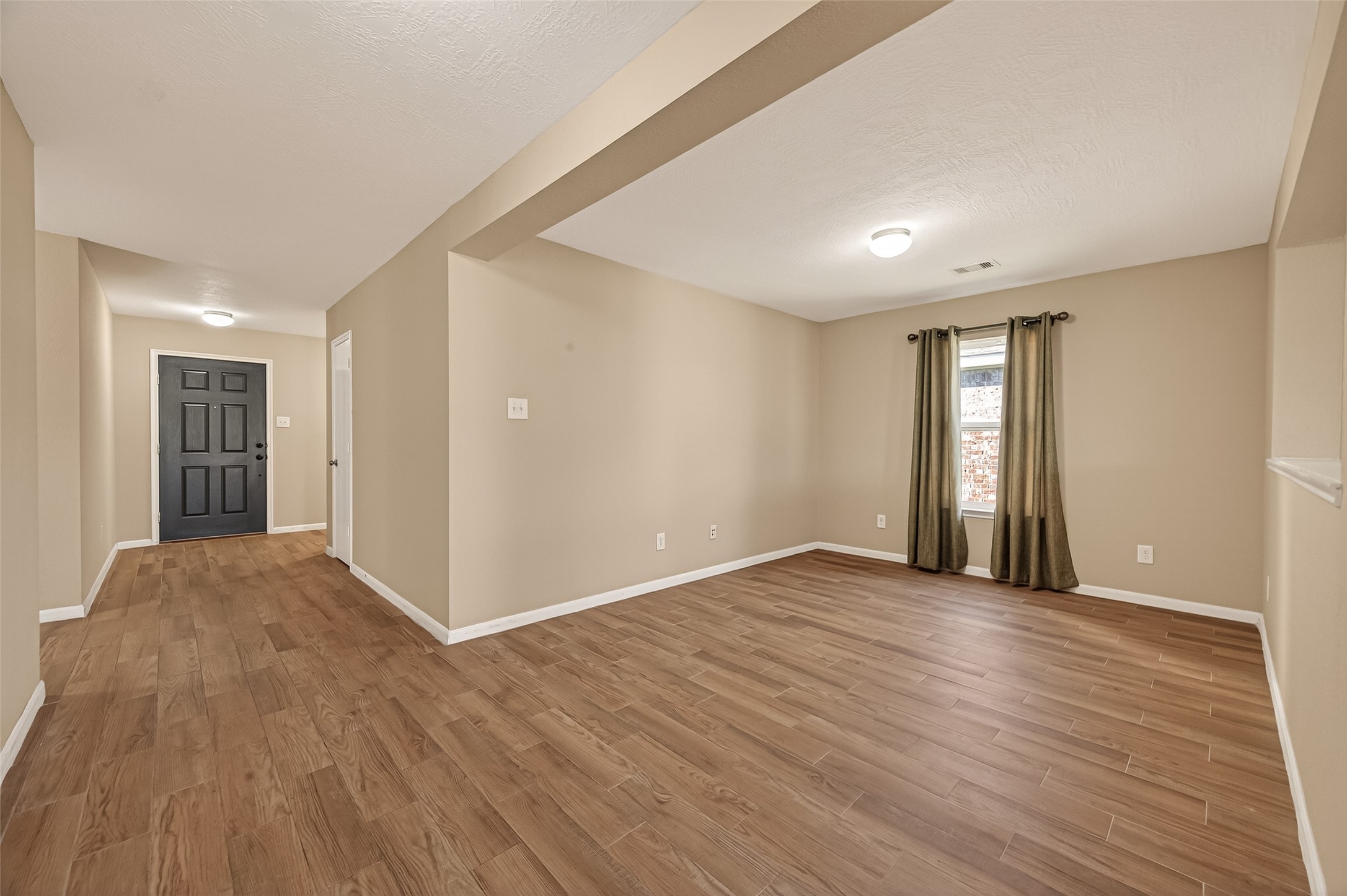 4515 Apache Point Drive Humble, TX 77396 - Photo 5 of 36 a view of an empty room with wooden floor and a window