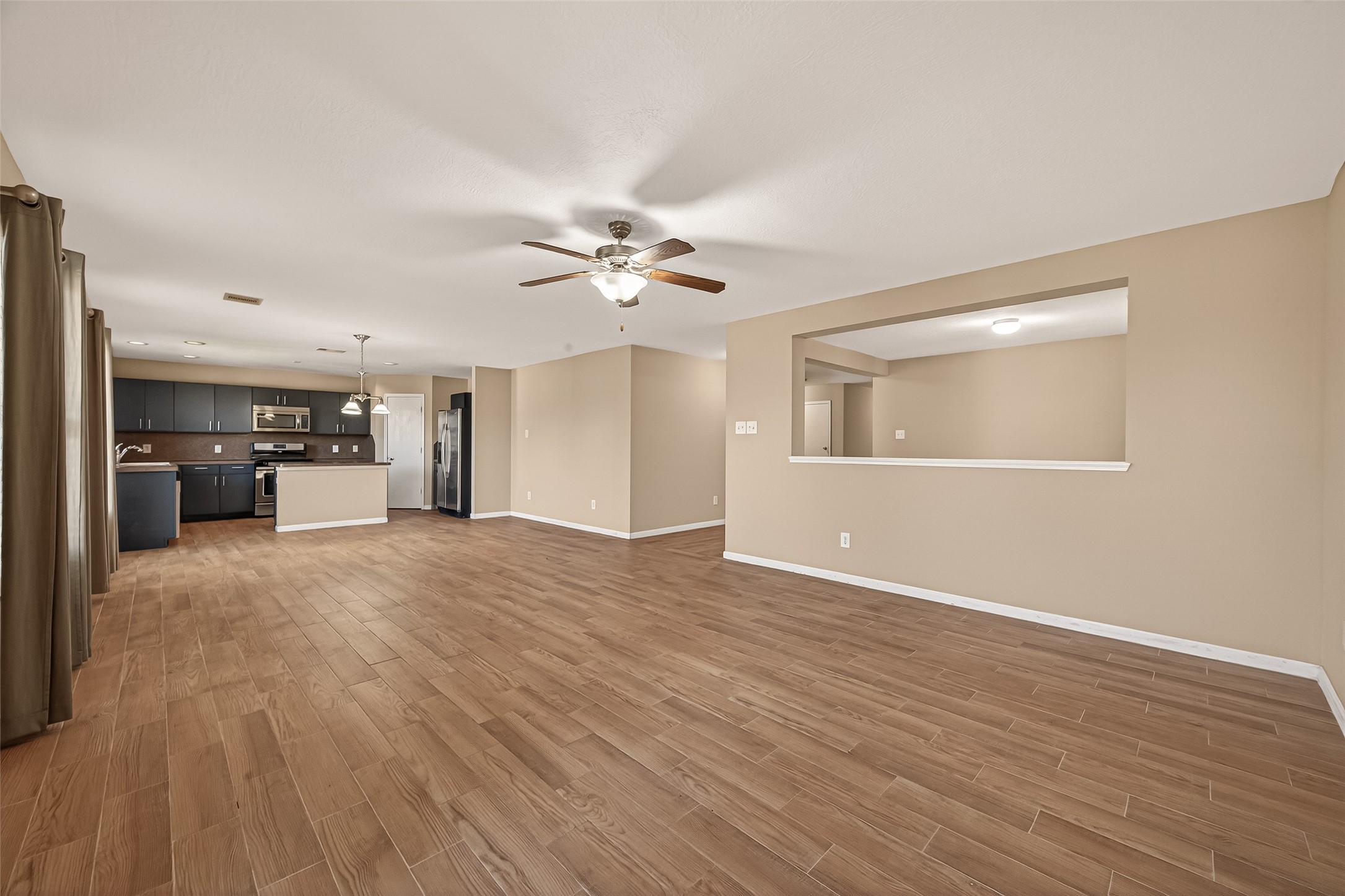 4515 Apache Point Drive Humble, TX 77396 - Photo 9 of 36 a view of a livingroom with a kitchen space with wooden floors